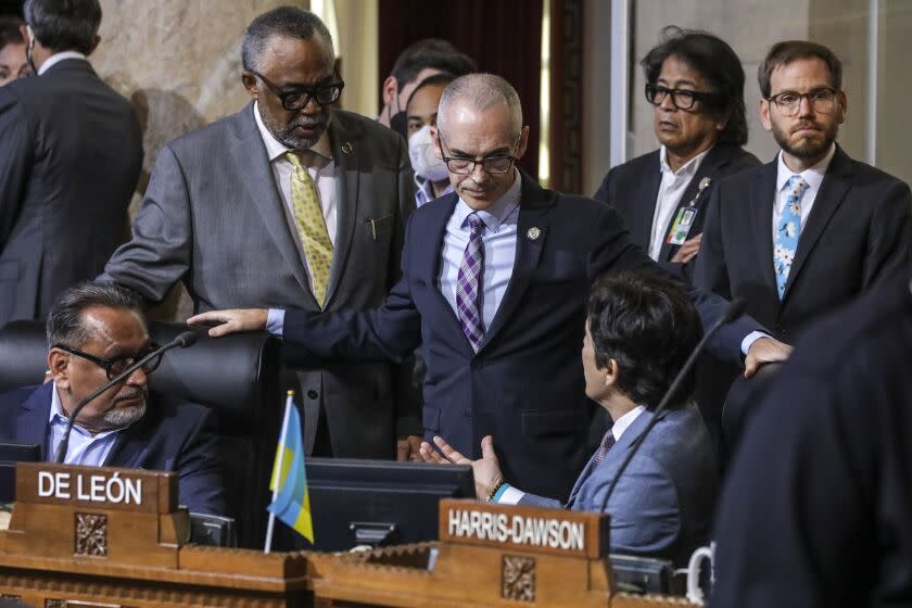 Los Angeles, CA - October 11: Councilman Curren D. Price, Jr., standing left, and Acting council president Mitch O'Farrell talk to council members Gil Cedillo, left, and Kevin de Leon who are under pressure from public to leave the meeting and resign. City Hall on Tuesday, Oct. 11, 2022 in Los Angeles, CA. (Irfan Khan / Los Angeles Times)