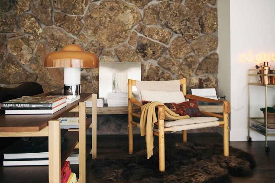 AFTER: An a safari chair from Norell Furniture sits atop a hide from Hygge Life in the living area, near a Luigi Massoni table lamp on a CB2 console.