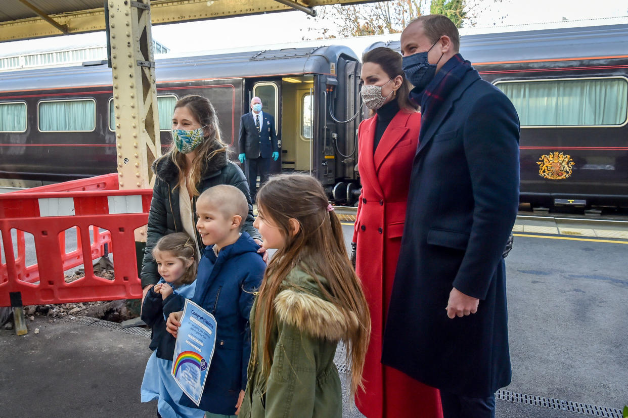 BATH, UNITED KINGDOM - DECEMBER 08: Prince William, Duke of Cambridge and Catherine, Duchess of Cambridge arrive at Bath Spa train station and take time to meet and chat with Otto Warner, 8, left, who has today come out of cancer treatment and was by chance hoping to meet the royal couple with his family, including sisters Jasmine Warner, 5, centre, Poppy, 10, right, and mum Georgie, ahead of a visit of the Duke and Duchess to a care home in the city to pay tribute to the efforts of care home staff throughout the COVID-19 pandemic on December 08, 2020 in Bath, England. The Duke and Duchess are undertaking a short tour of the UK ahead of the Christmas holidays to pay tribute to the inspiring work of individuals, organizations and initiatives across the country that have gone above and beyond to support their local communities this year. (Photo by Ben Birchall - Pool / Getty Images)