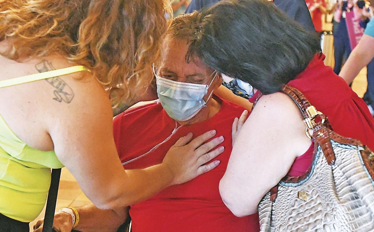 Alfonso Porches-Silva, center, a COVID-19 survivor, surrounded by his daughter Alexandra Porchas (left) and his wife Candie Porchas (right), gets emotional as Yuma Regional Medical Center personnel give him a special "CODE YUMA STRONG" sendoff, in Yuma, Ariz. on May 20, 2020.