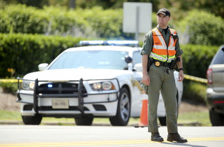 A law enforcement officer is seen on the road in front of the Bridgewater Plaza in Moneta, Virginia, August 26, 2015. REUTERS/Chris Keane