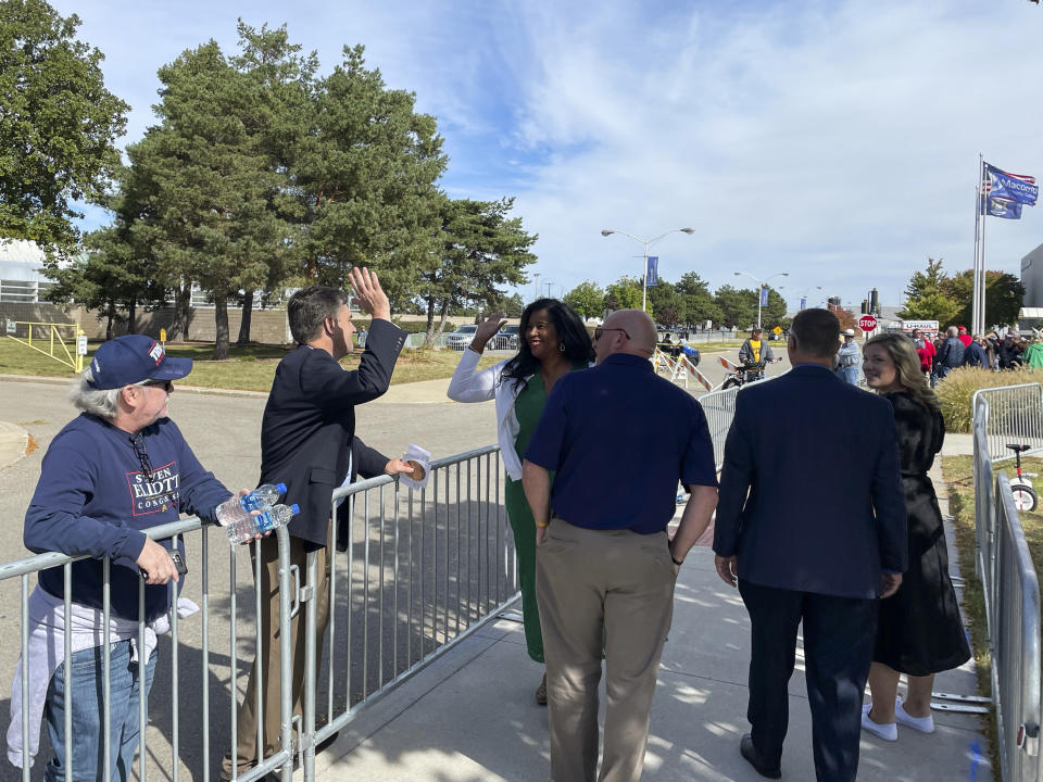 Kristina Karamo, the Republican nominee for Michigan's secretary of state, high fives prominent election denier and former state Sen. Patrick Colbeck outside a rally for President Donald Trump in Warren, Mich., Saturday, Oct. 1, 2022. (AP Photo/Joey Cappelletti)