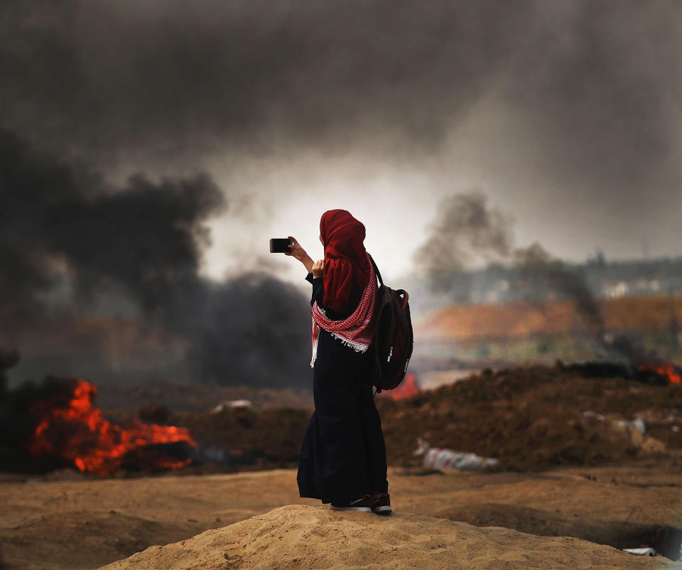A Palestinian woman documents the situation at the border fence with Israel in Gaza City, Gaza.&nbsp;