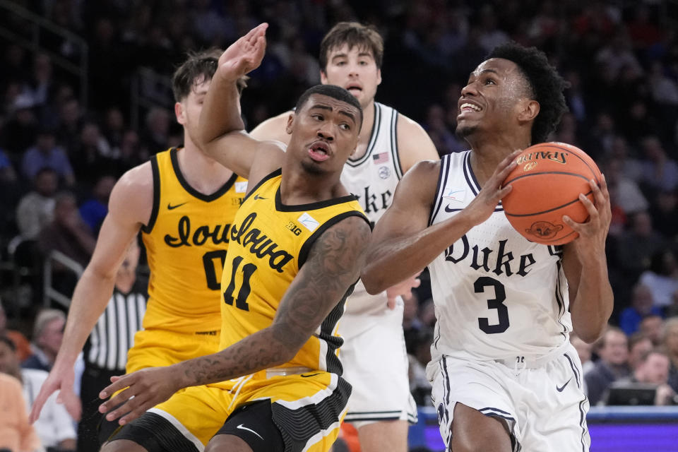 Duke's Jeremy Roach (3) dives to the net against Iowa's Tony Perkins (11) during the first half of an NCAA college basketball game in the Jimmy V Classic, Tuesday, Dec. 6, 2022, in New York. (AP Photo/John Minchillo)