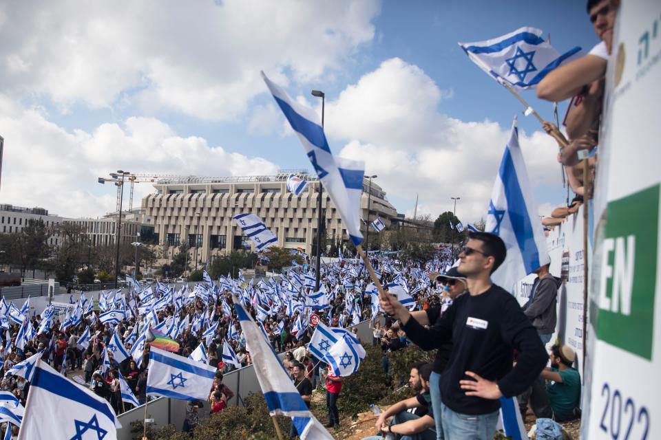 Protestors wave flags in Jerusalem on 27 March 2023 (Getty Images)