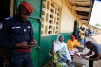 People wait for the opening of a polling station during the legislative election in Abidjan