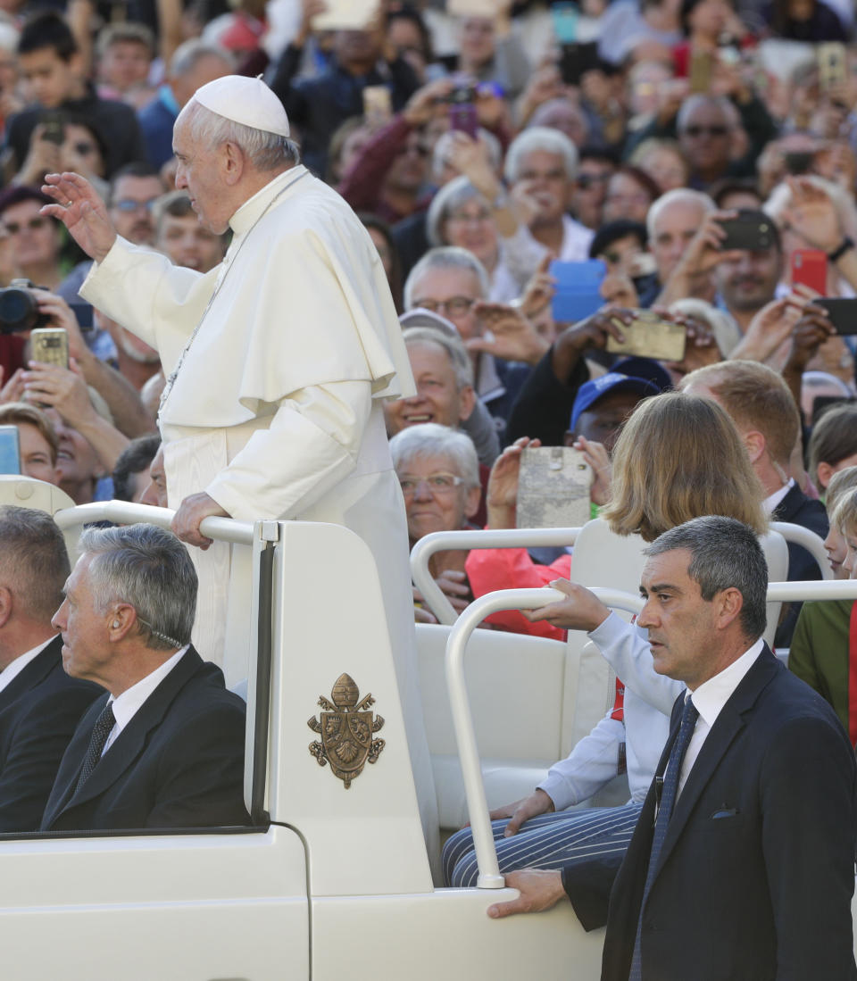 Pope Francis, flanked by newly appointed Vatican head of security Gianluca Gauzzi Broccoletti, bottom right, arrives for his weekly general audience, in St.Peter's Square, at the Vatican, Wednesday, Oct. 16, 2019. (AP Photo/Andrew Medichini)