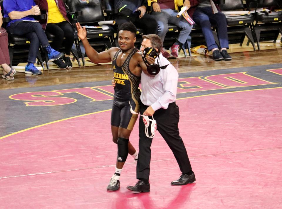 Arizona State 157-pounder Jacori Teemer walks out with head coach Zeke Jones after winning by an 11-5 decision over Oklahoma's Justin Thomas during the Sun Devils' home opener at Desert Financial Arena in Tempe on Nov. 19, 2021.