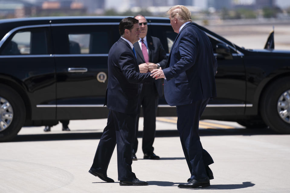 Gov. Doug Ducey, R-Ariz., greets President Donald Trump as he arrives at Phoenix Sky Harbor Airport, Tuesday, May 5, 2020, in Phoenix. (AP Photo/Evan Vucci)                                                                                                                                                                          