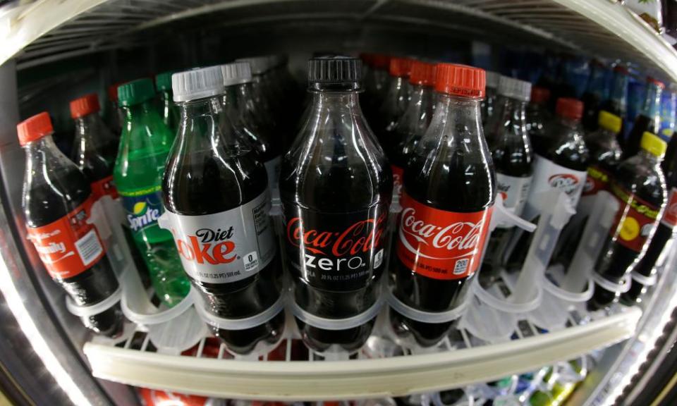 a shelf of soft drinks are shown in a refrigerator in a photo taken with a fish eye lens. 