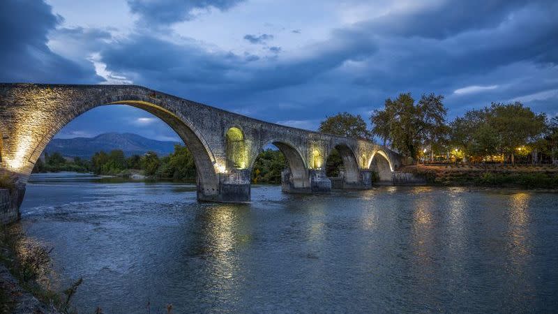 illuminated bridge of arta on arachthos river at night in greece