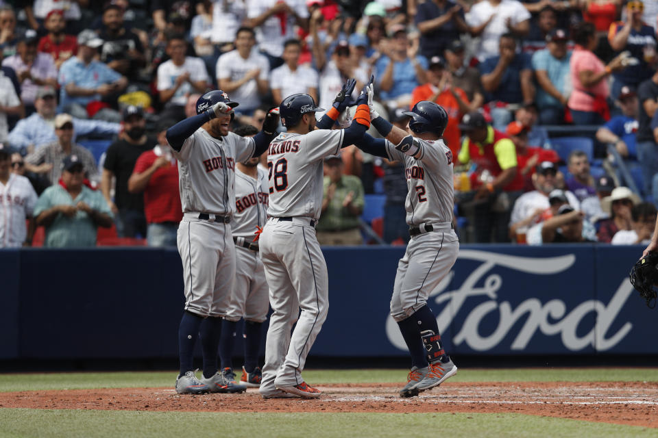 Teammates celebrate a grand slam by Houston Astros' Alex Bregman, right, in the fifth inning of a baseball game against the Los Angeles Angels, in Monterrey, Mexico, Sunday, May 5, 2019. (AP Photo/Rebecca Blackwell)