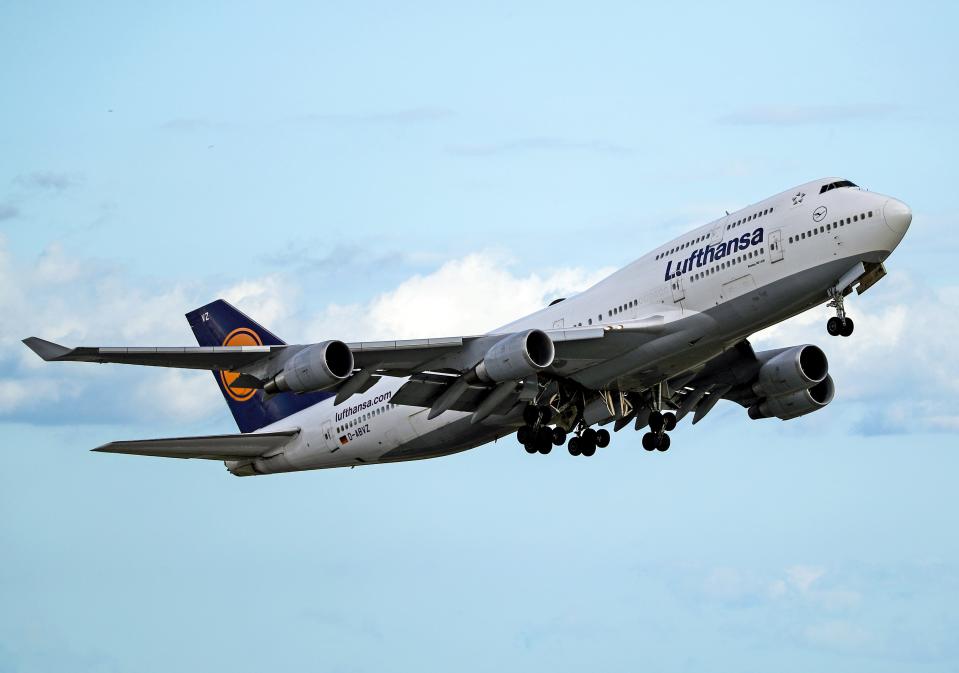 A Lufthansa Boeing 747 taking off against a blue sky