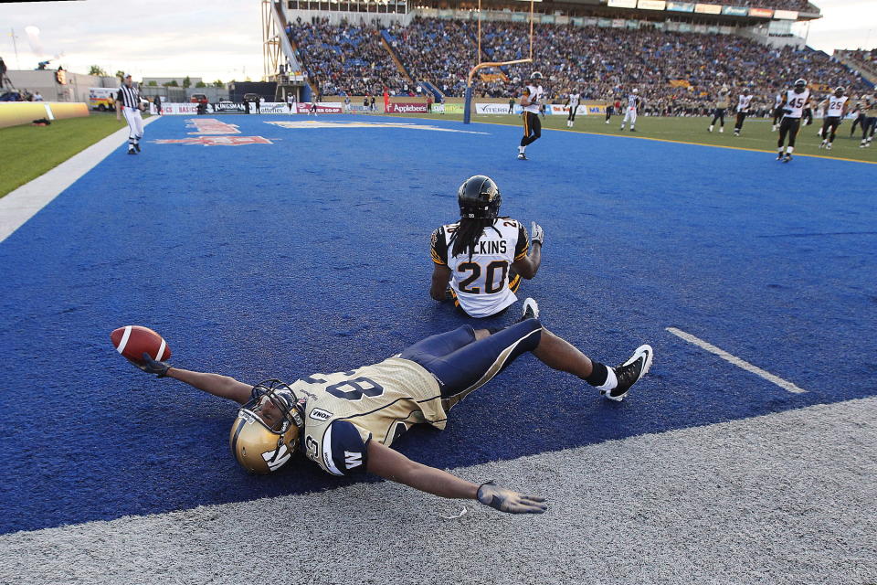 Winnipeg Blue Bombers' Doug Pierce (83) celebrates his touchdown against Hamilton Tiger-Cats' Josh Wilkins (20) during the second half of their pre-season CFL game in Winnipeg Wednesday, June 20, 2012. THE CANADIAN PRESS/John Woods