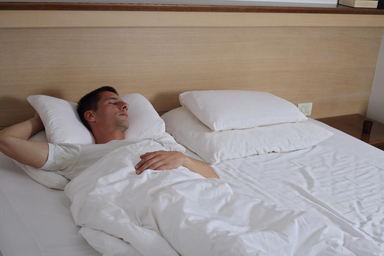 Young handsome man sleeping comfortably in bed.