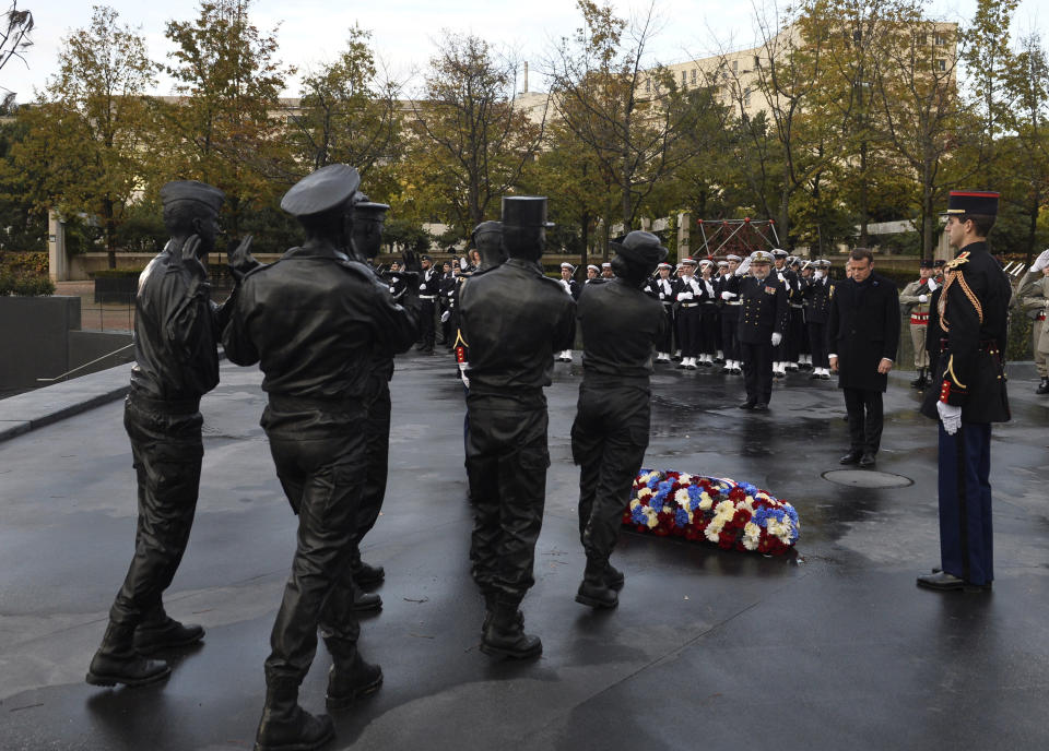 French President Emmanuel Macron inaugurates a memorial for soldiers fallen in foreign conflicts, Monday Nov. 11, 2019 in Paris. As part of commemorations marking 101 years since World War I's Armistice, French President Emmanuel Macron led a ceremony for the 549 French soldiers who died in 17 theaters of conflict since the 60s. The monument memorial depicts six soldiers _ five men and a woman _ holding up an invisible coffin. (Johanna Geron/Pool via AP)