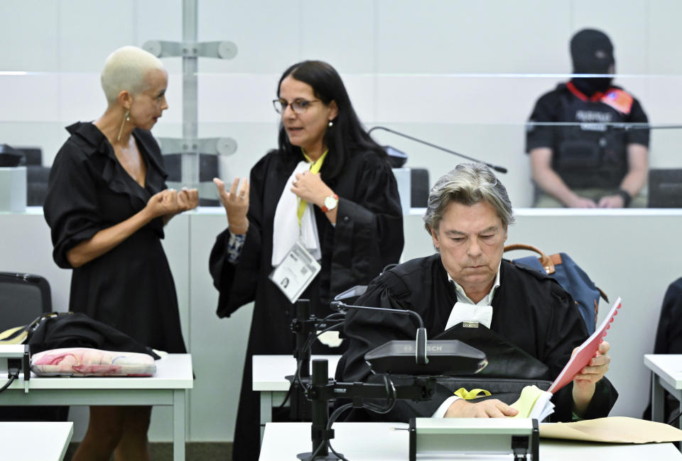 Gisele Stuyck, lawyer of defendant Osama Krayem, left, speaks with lawyer Delphine Paci, second left, as Michel Bouchat, lawyer of defendant Salah Abdeslam, attends the courtroom prior to the reading of the sentences during the trial regarding the attacks at a Brussels metro station and the city's airport at the Justitia building in Brussels, Friday, Sept. 15, 2023. The morning rush hour attacks at Belgium's main airport and on the central commuter line took place on March 22, 2016, which killed 32 people, and nearly 900 others were wounded or suffered mental trauma. (John Thys, Pool Photo via AP)