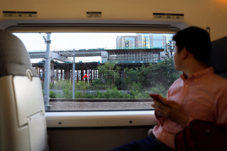 Chinese flags are seen outside a train during the first day of service of the Hong Kong Section of the Guangzhou-Shenzhen-Hong Kong Express Rail Link, in Shenzhen, China September 23, 2018. REUTERS/Tyrone Siu