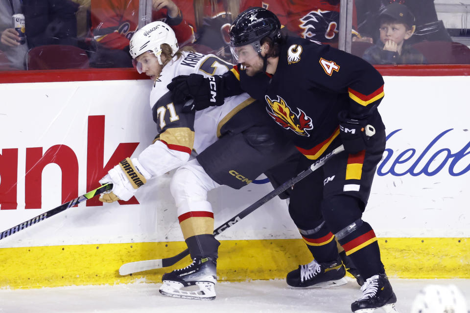 Vegas Golden Knights' William Karlsson, left, battles with Calgary Flames' Rasmus Andersson during the first period of an NHL hockey game, Thursday, March 14, 2024 in Calgary, Alberta. (Larry MacDougal/The Canadian Press via AP)