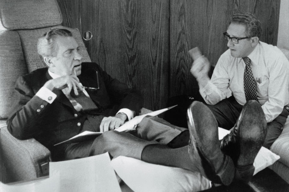 (Original Caption) Up in the Air. Undated: President Richard Nixon and Secretary of State Henry Kissinger confer aboard Air Force One as it heads towards Brussels, Belgium, June 26th, and NATO talks. Nixon rests his legs on a pillow atop a table to ease an attack of Phlebitis which struck recently. After the Brussels talks, President Nixon headed for Moscow and summit talks with Soviet leader Leonid Brezhnev.