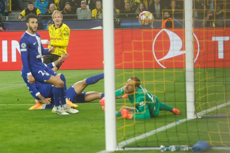 Dortmund's German midfielder #19 Julian Brandt (bsck L) scores the opening goal past Atletico Madrid's Slovenian goalkeeper #13 Jan Oblak (R) during the UEFA Champions League quarter-final second leg football match between Borussia Dortmund and Atletico Madrid in Dortmund, western Germany on April 16, 2024. (Photo by Odd ANDERSEN / AFP)