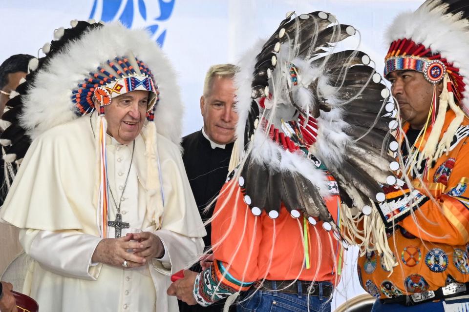 Pope Francis wears a headdress presented to him by Indigenous leaders during a meeting at Muskwa Park in Maskwacis, Alberta, Canada, on July 25, 2022. Pope Francis will make a historic personal apology Monday to Indigenous survivors of child abuse committed over decades at Catholic-run institutions in Canada, at the start of a week-long visit he has described as a "penitential journey." 