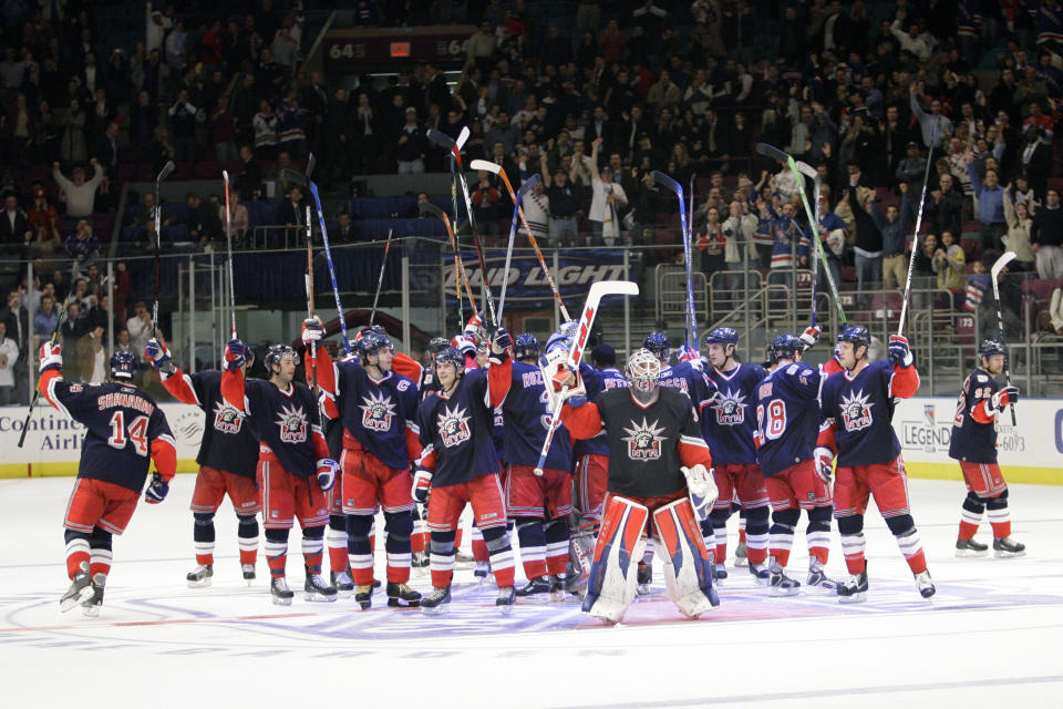 FILE - In this Tuesday, Nov. 14, 2006, file photo, New York Rangers' goalie Henrik Lundqvist, foreground center, of Sweden, celebrates beating the New Jersey Devils with his teammates at the end of the NHL hockey game at Madison Square Garden in New York. The Rangers defeated the Devils 3-2. The New York Rangers have bought out the contract of star goaltender Henrik Lundqvist. The Rangers parted with one of the greatest netminders in franchise history on Wednesday, Sept. 30, 2020, when they paid off the final year of his contract. (AP Photo/Mary Altaffer)