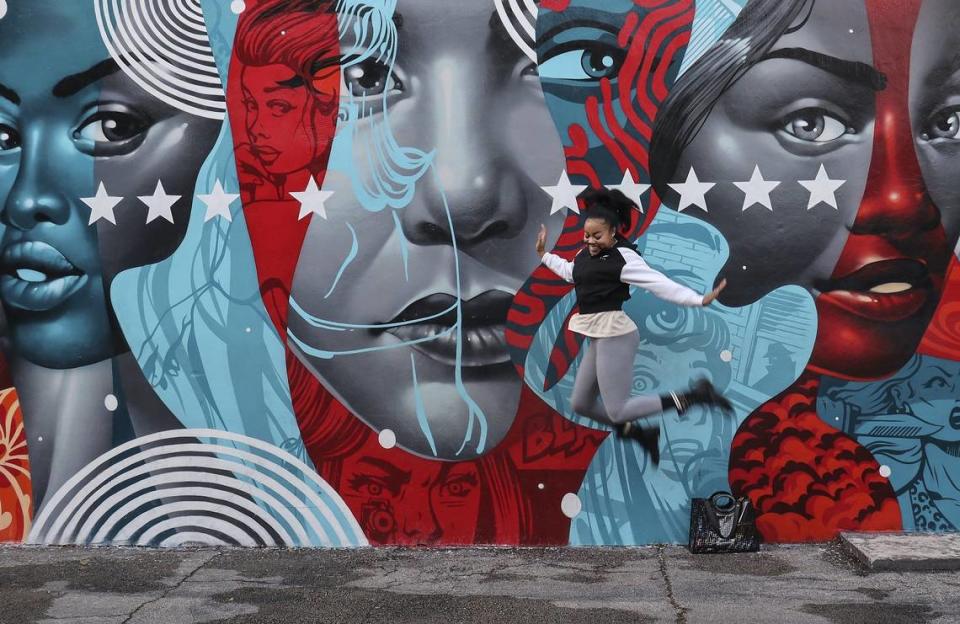 Tia Williams, who is visiting from Memphis, TN, leaps in the air while a friend takes a photo in front of a mural by artist Tristan Eaton inside Wynwood Walls on Sunday, November 25, 2019.