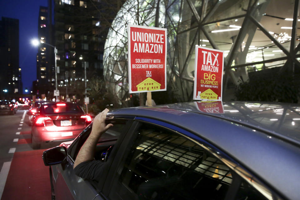 A sign supporting Amazon workers unionizing in Bessemer, Alabama, is pictured on a car during a Tax Amazon Car Caravan and Bike Brigade around the Amazon Spheres to defend a payroll-based tax on big businesses, including Amazon, that passed last July in Seattle, Washington, on Feb. 20. (Photo: JASON REDMOND/AFP/Getty Images)