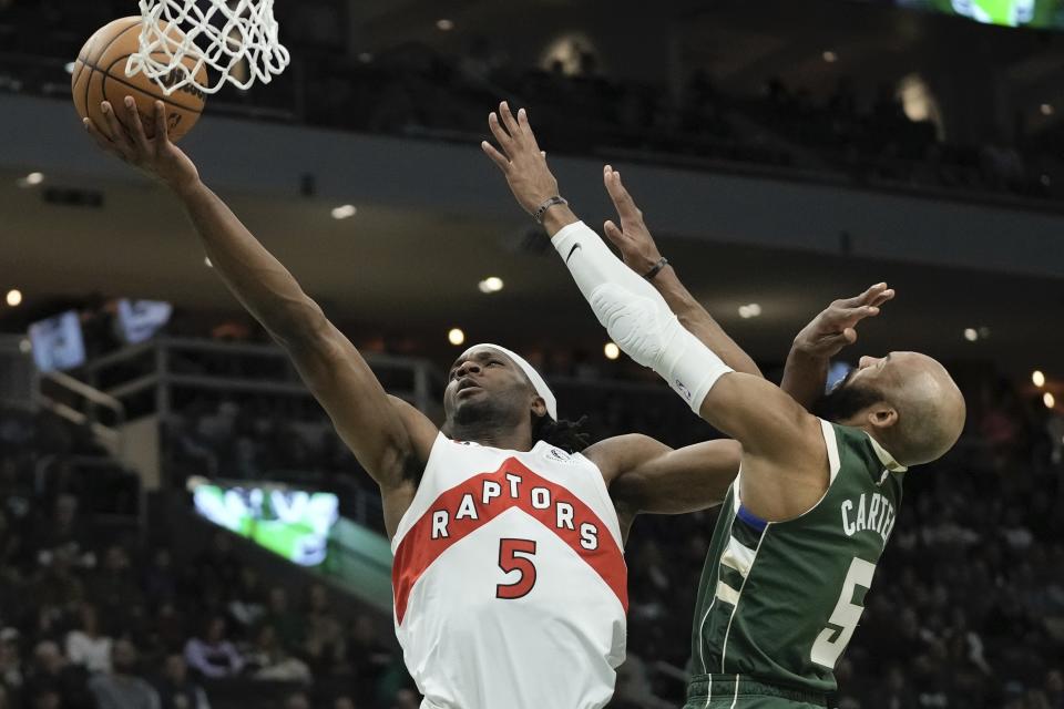 Toronto Raptors' Precious Achiuwa shoots past Milwaukee Bucks' Jevon Carter during the first half of an NBA basketball game Tuesday, Jan. 17, 2023, in Milwaukee. (AP Photo/Morry Gash)