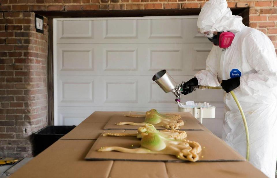 Abby Decker airbrushes a silicone top piece in the loading dock area of the building and wears a full protective suit, goggles, and a respirator to mitigate the harm of repeatedly breathing in the paint’s chemicals.