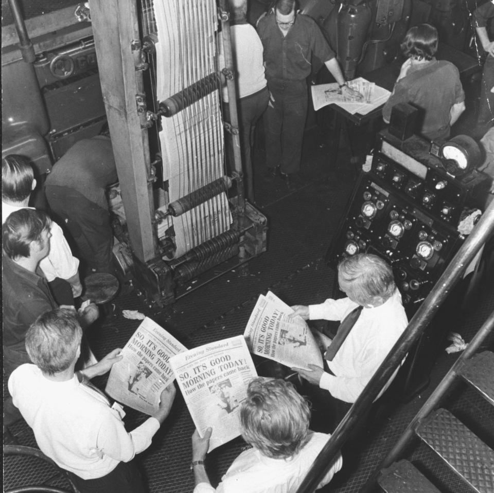 Workers check the night edition of the Evening Standard as it comes off the press