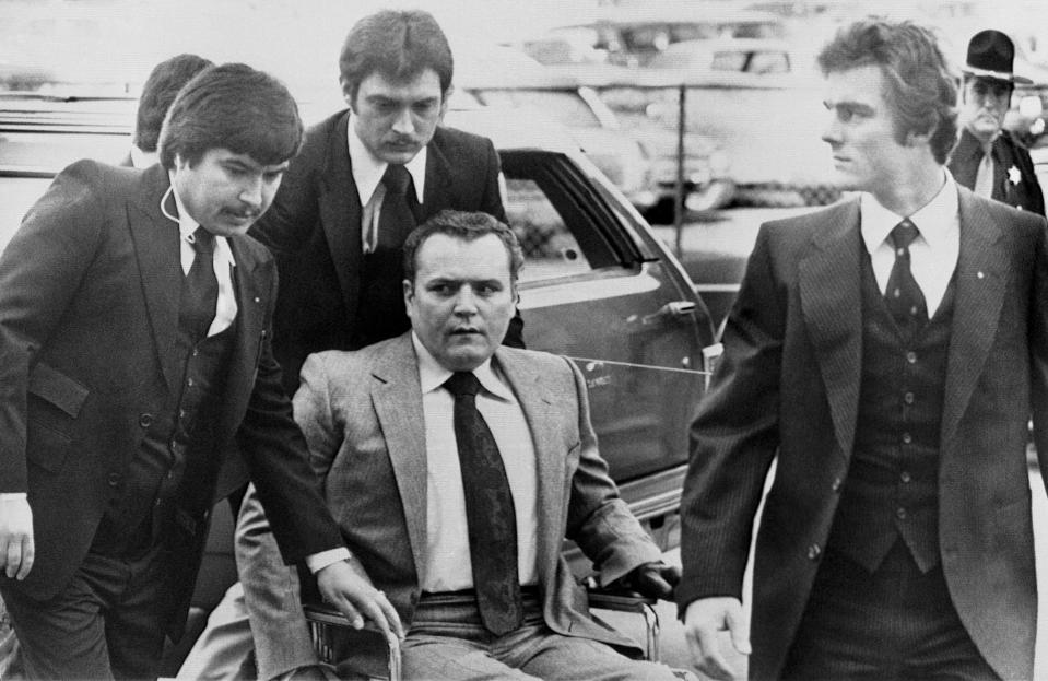 FILE - "Hustler" magazine publisher Larry Flynt is surrounded by heavy security as he arrives at the Fulton County Courthouse in Atlanta on March 19, 1979, for the start of his trial on obscenity charges. Flynt, who turned "Hustler" magazine into an adult entertainment empire while championing First Amendment rights, has died at age 78. His nephew, Jimmy Flynt Jr., told The Associated Press that Flynt died Wednesday, Feb. 10, 2021, of heart failure at his Hollywood Hills home in Los Angeles. (AP Photo/Steve Helber, File)