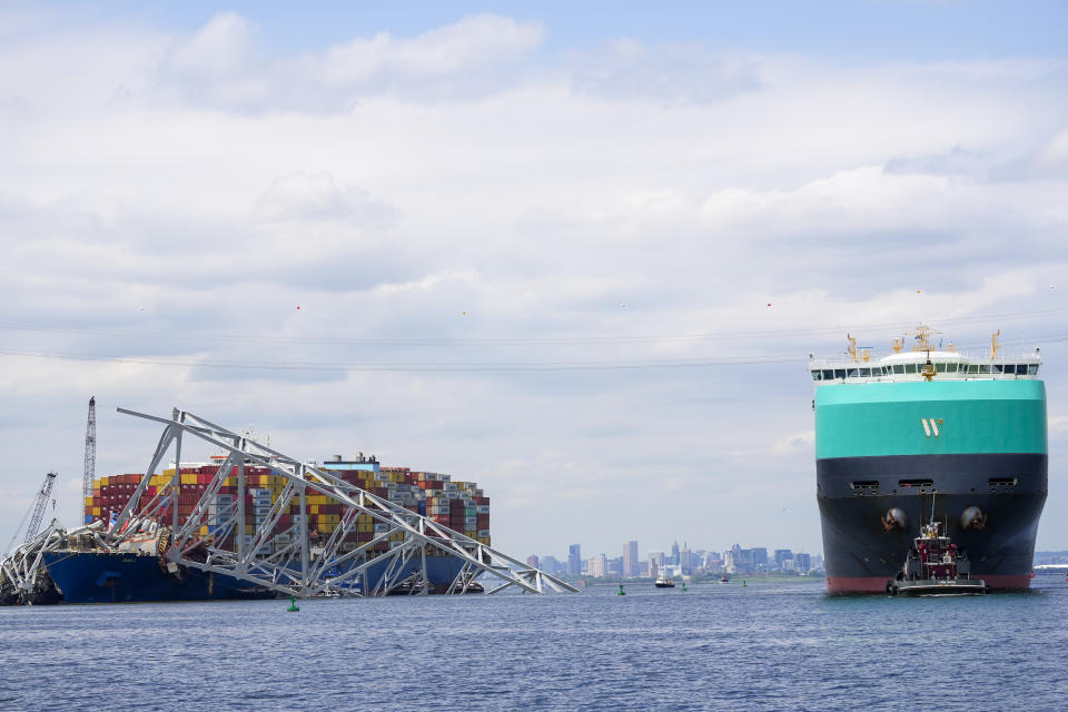 A vessel, right, moves past the stranded container ship Dali, through a newly opened deep-water channel in Baltimore after being stuck in the harbor since the Francis Scott Key Bridge collapsed four weeks ago, Thursday, April 25, 2024. (AP Photo/Matt Rourke)