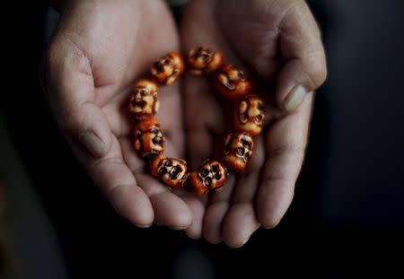 Gao Zhao, 56, shows a bracelet which his dead son wore, at the house where his son lived in Zhangjiakou, China, November 21, 2015. REUTERS/Kim Kyung-Hoon