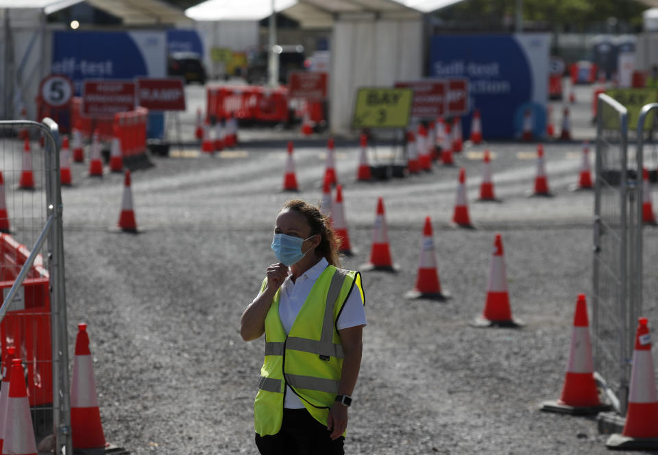 Staff waits in front of empty lanes of a Covid-19 drive thru testing facility at Twickenham stadium in London, Thursday, Sept. 17, 2020. Britain has imposed tougher restrictions on people and businesses in parts of northeastern England on Thursday as the nation attempts to stem the spread of COVID-19, although some testing facilities remain under-utilised. (AP Photo/Frank Augstein)