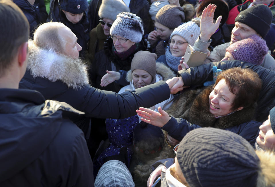 Russian President Vladimir Putin, second left, greets people taking part at a wreath laying ceremony at the Piskaryovskoye Cemetery, in St. Petersburg, Russia, Sunday, Jan. 27, 2019, where most of the Leningrad Siege victims were buried during World War II. The Russian city of St. Petersburg marked the 75th anniversary of the end of the World War II siege by Nazi forces. The siege of the city, then called Leningrad, lasted nearly two and a half years until the Soviet Army drove the Nazis away on Jan. 27, 1944. (Mikhail Klimentyev, Sputnik, Kremlin Pool Photo via AP)