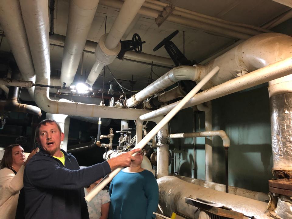 Adam Reynolds, head of maintenance for North Fork Local Schools, shows how high water reached in the boiler room at Utica Middle School during a flood. Reynolds was conducting a tour of the building during a community meeting about the upcoming bond issue on the ballot.