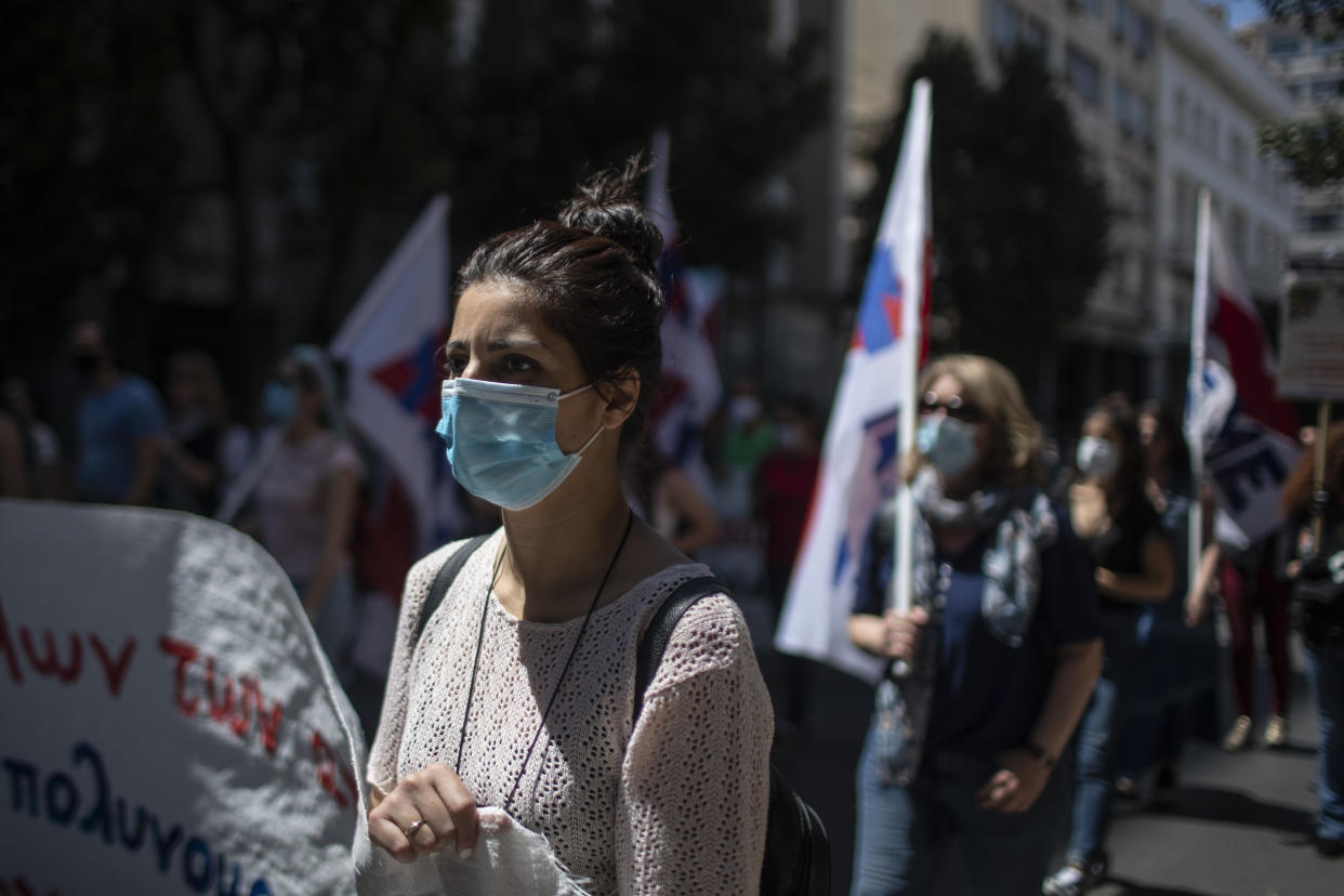 Greek state school teachers and students, wearing masks to prevent the spread of the coronavirus, protest in Athens, on Wednesday, May 13, 2020. Unions oppose government plans to allow remote teaching with use of a camera that will show the blackboard as part of the government's response to the coronavirus pandemic .(AP Photo/Petros Giannakouris)