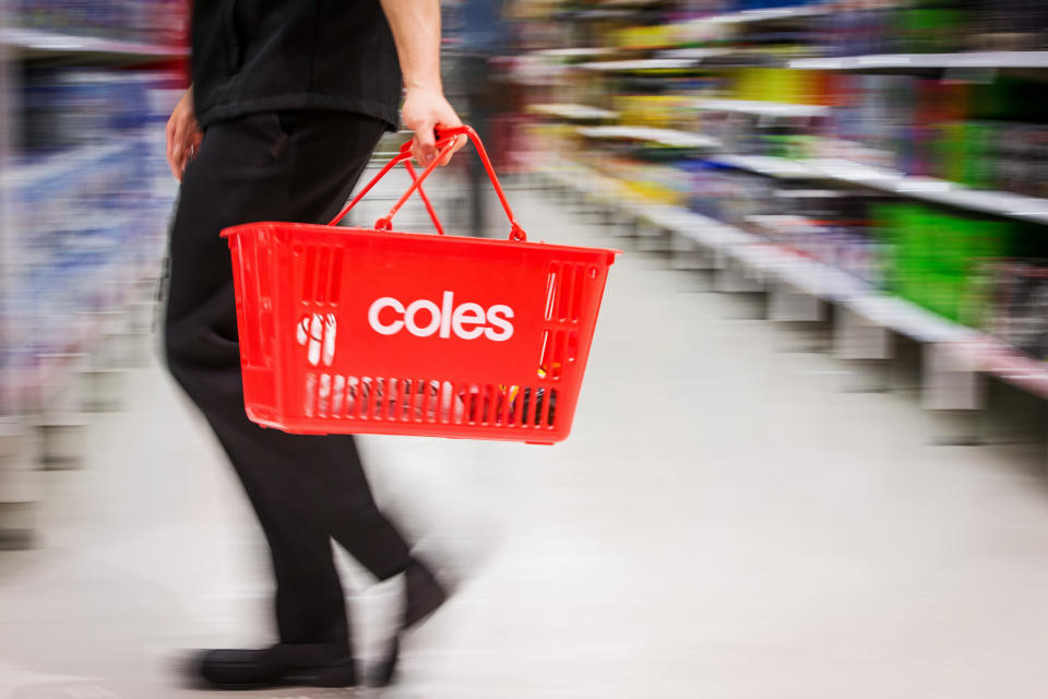 Image of shopper holding Coles supermarket basket