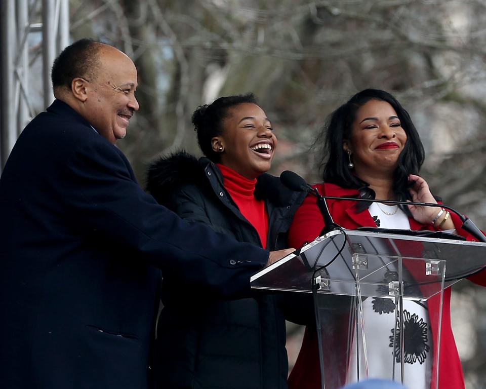 Yolanda Renee King, 14, center, jokes that her late grandparents, the Rev. Martin Luther King Jr. and Coretta Scott King, must be really excited after her notes were blown off the podium by a gust of wind while standing next to her parents, Martin Luther King III, and Andrea Waters King, during the unveiling ceremony Friday of "The Embrace" on Boston Common.