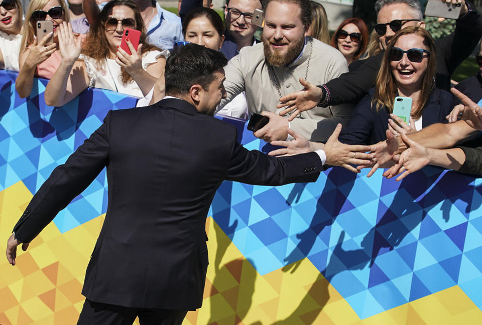 Ukrainian President-elect Volodymyr Zelenskiy greets supporters before his inauguration ceremony in Kiev, Ukraine, Monday, May 20, 2019. Television star Volodymyr Zelenskiy has been sworn in as Ukraine's next president after he beat the incumbent at the polls last month. The ceremony was held at Ukrainian parliament in Kiev on Monday morning. (AP Photo/Evgeniy Maloletka)