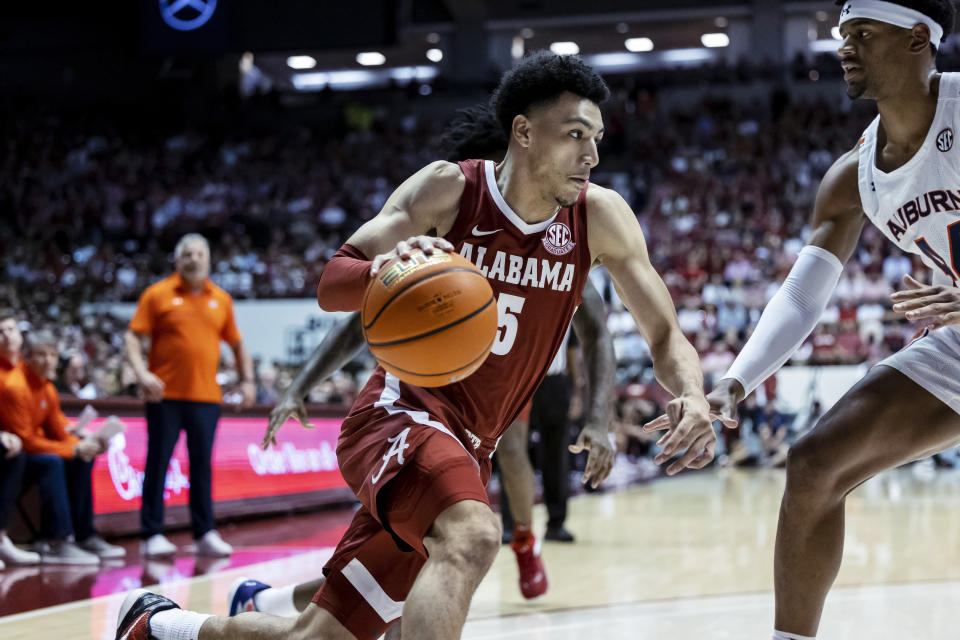 Alabama guard Jahvon Quinerly (5) drives against Auburn center Dylan Cardwell (44) during the first half of an NCAA college basketball game Wednesday, March 1, 2023, in Tuscaloosa, Ala. (AP Photo/Vasha Hunt)