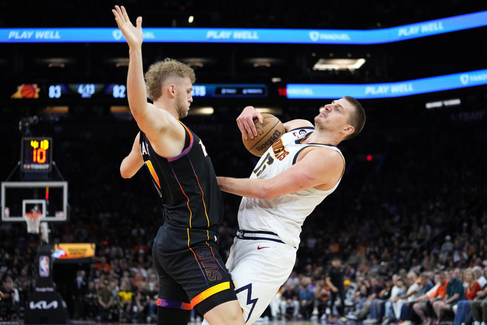 Denver Nuggets center Nikola Jokic collides with Phoenix Suns center Jock Landale, left, during the second half of Game 4 of an NBA basketball Western Conference semifinal game, Sunday, May 7, 2023, in Phoenix. The Suns defeated the Nuggets 129-124. (AP Photo/Matt York)