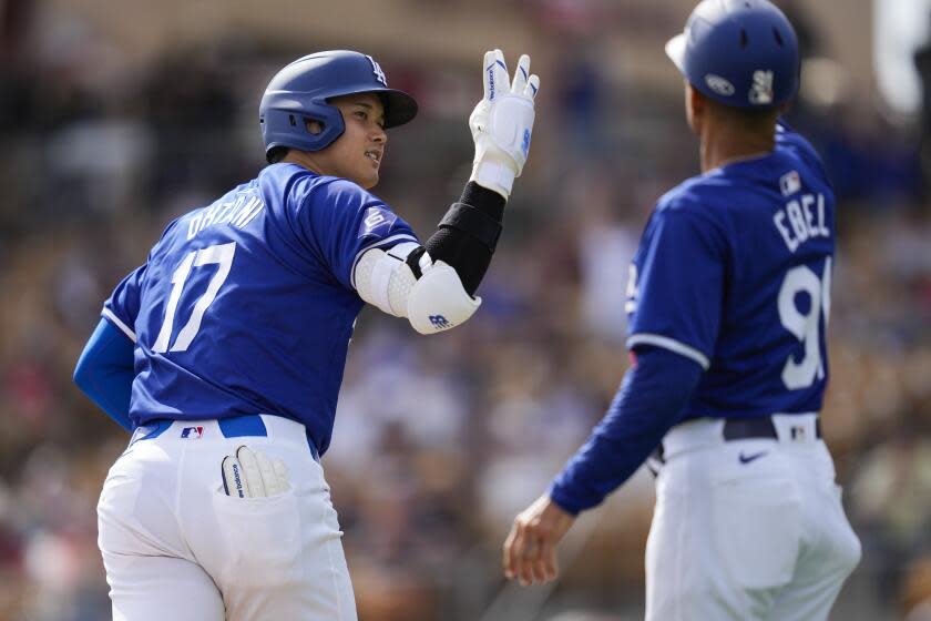 Dodgers' Shohei Ohtani celebrates with third base coach Dino Ebel after hitting a home run on Feb. 27, 2024, in Phoenix.