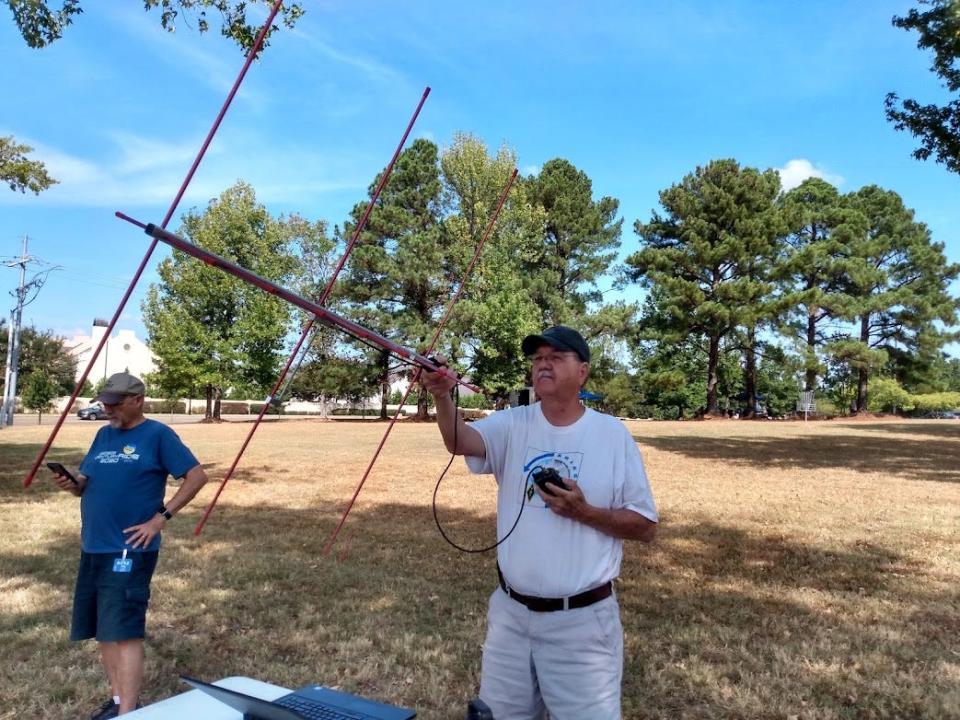 Radio Club member Eddie Pettis, right, uses a hand-held “Aero Antenna” to pick up communications relayed by satellite in the VHF and UHF frequencies as Clay Quarterman uses a cell phone app to track the exact location of the communications satellite.