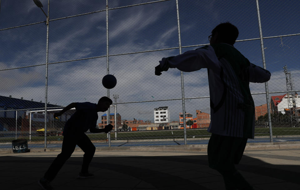 En esta imagen del 18 de enero de 2020, las siluetas de dos jóvenes jugando al fútbol en un recinto deportivo en El Alto, Bolivia. En 2007, Morales inició un programa social que denominó “Bolivia Cambia, Evo Cumple”, financiado por donaciones del entonces presidente venezolano Hugo Chávez, y que luego mantuvo con recursos estatales. Con ese dinero, Morales --que era fanático del fútbol-- financió canchas con césped sintético a las que luego se sumaron polideportivos, escuelas, hospitales. (AP Foto/Juan Karita)