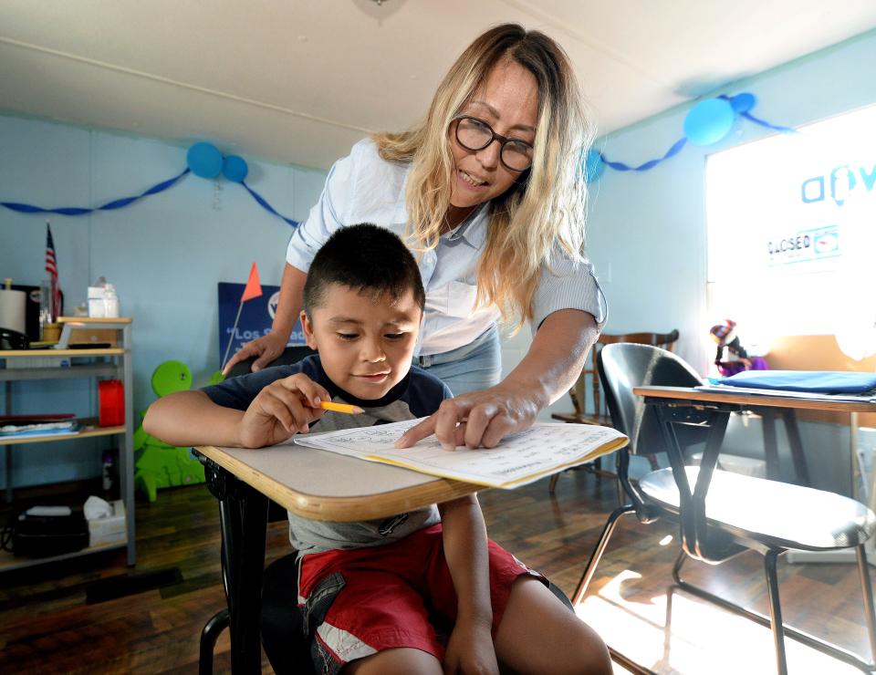 Director of the Welcome Center Kelly Hamlin helps Junior Gonzales, 6, with his homework after school at the Western Illinois Dreamers Thursday Sept. 8, 2022.