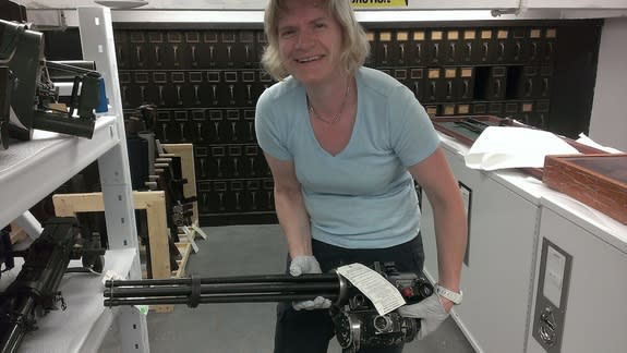 Julie Kowalsky holds up an experimental minigun designed by Capt. John A. Dahlgren. This mini-machine gun never went into production.