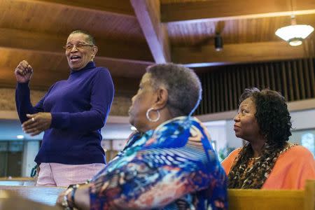 A woman stands up to give thanks for volunteers who helped her clean up her vandalized business during a Thanksgiving service that discussed the communities reaction to ongoing protests in reaction to the grand jury verdict in the Michael Brown shooting in Ferguson, Missouri November 27, 2014. A small but spirited congregation assembled at the Greater St. Mark Family Church, a gathering point for protesters and religious leaders, for the Thanksgiving service where many offered appreciation for their blessings after a tumultuous week. REUTERS/Lucas Jackson